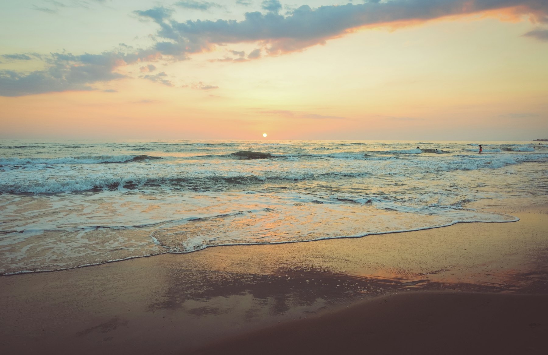 Waves rolling onto the beach at sunset